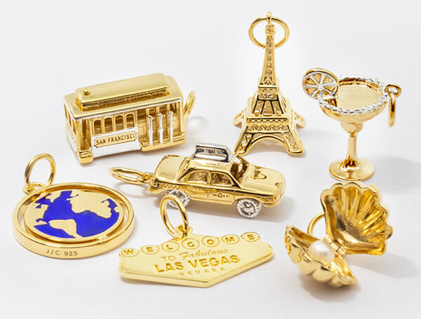 Solid Gold Charms and Charm Bracelets including a solid gold Eiffel Tower Charm, a New York City Taxi Charm and other travel-inspired charms