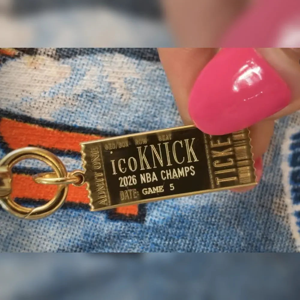 a gold personalized ticket charm with the engraving icoKNICK 
