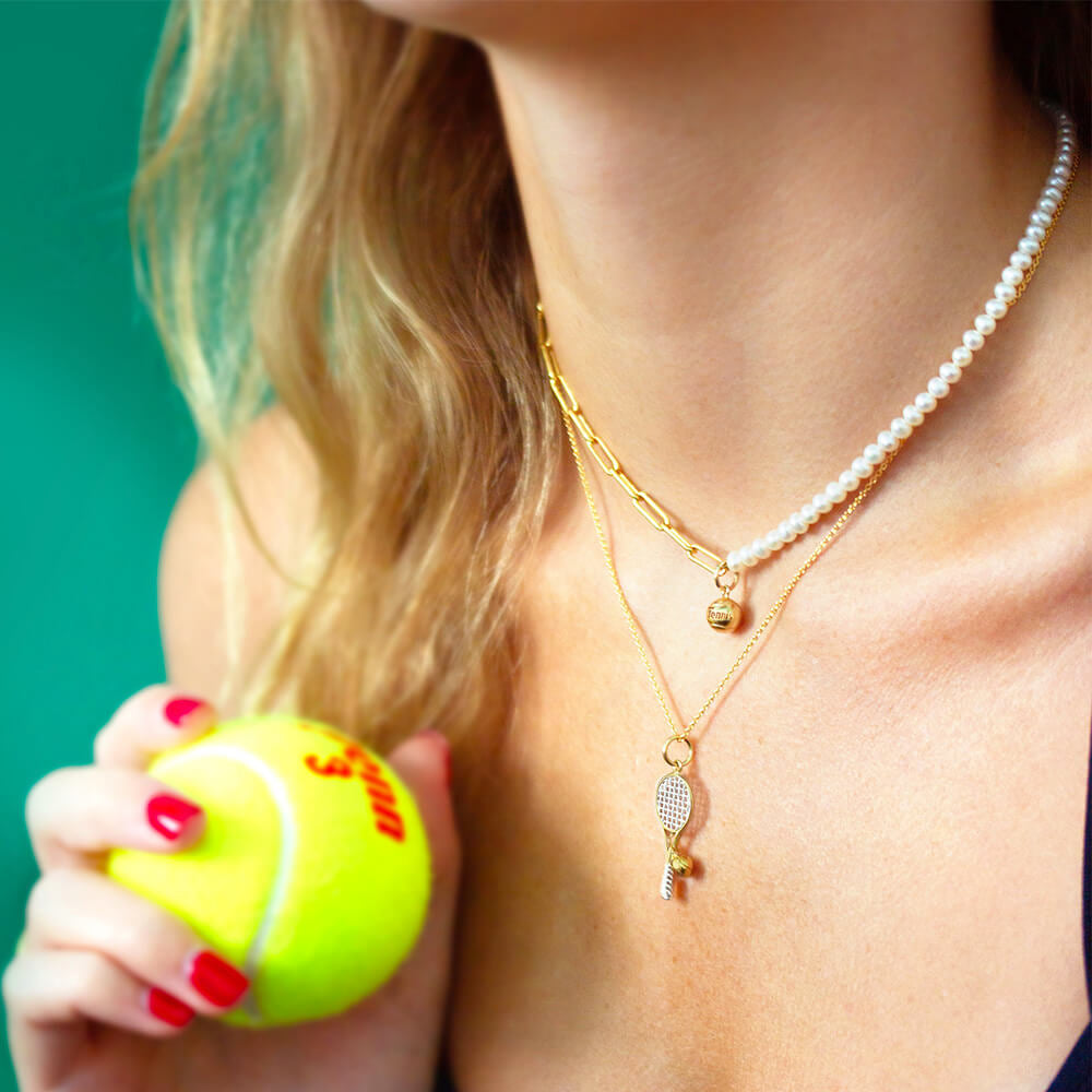 gold two toned tennis racquet charm on cable chain and solid gold mini tennis ball charm on pearl paperclip chain