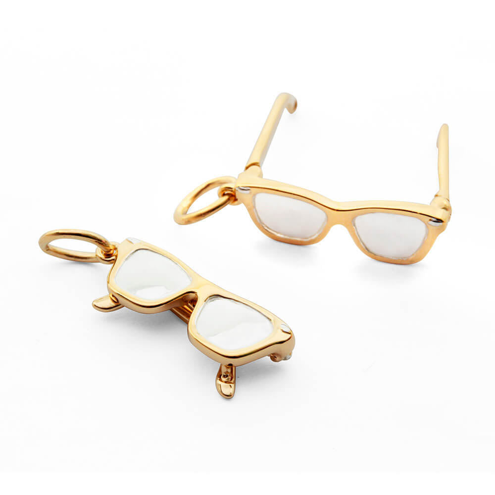 Gold Charm in the shape of eyeglasses featuring a 3D frame design with white enamel lenses and bail.