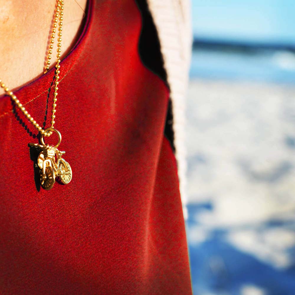 Gold vermeil bike charm on a ball chain necklace by Jet Set Candy, showcasing a delicate bicycle design on a white background.