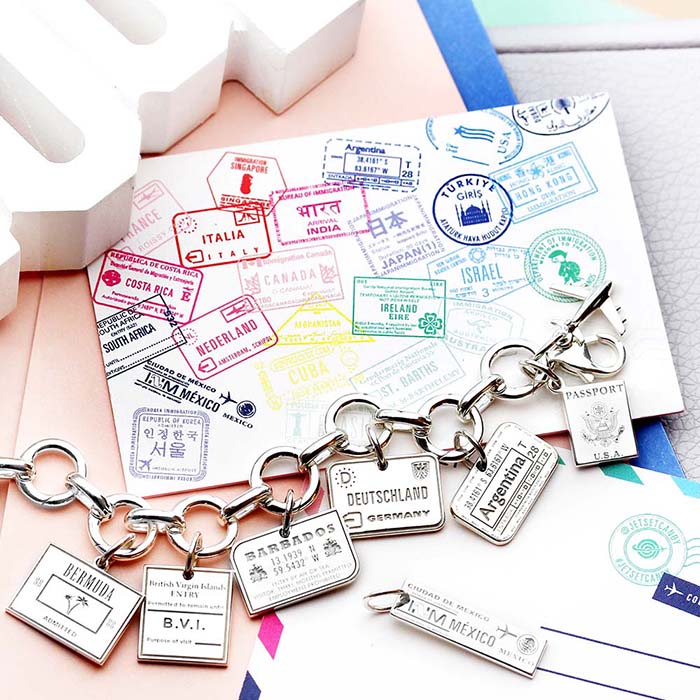 Sterling Silver charm bracelet featuring travel tags for Bermuda, Barbados, Deutschland, Argentina, and Mexico with an airplane and passport.