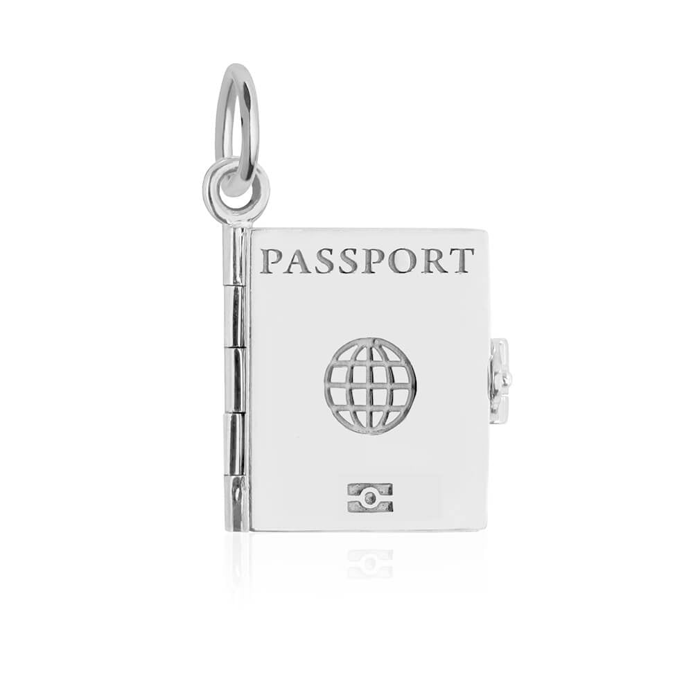Silver global passport book charm by Jet Set Candy, showcasing travel-inspired engravings on a white background.
