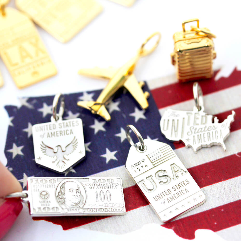 Sterling Silver Charms including a hundred dollar bill, eagle emblem, USA luggage tag, and map silhouette over American flag.