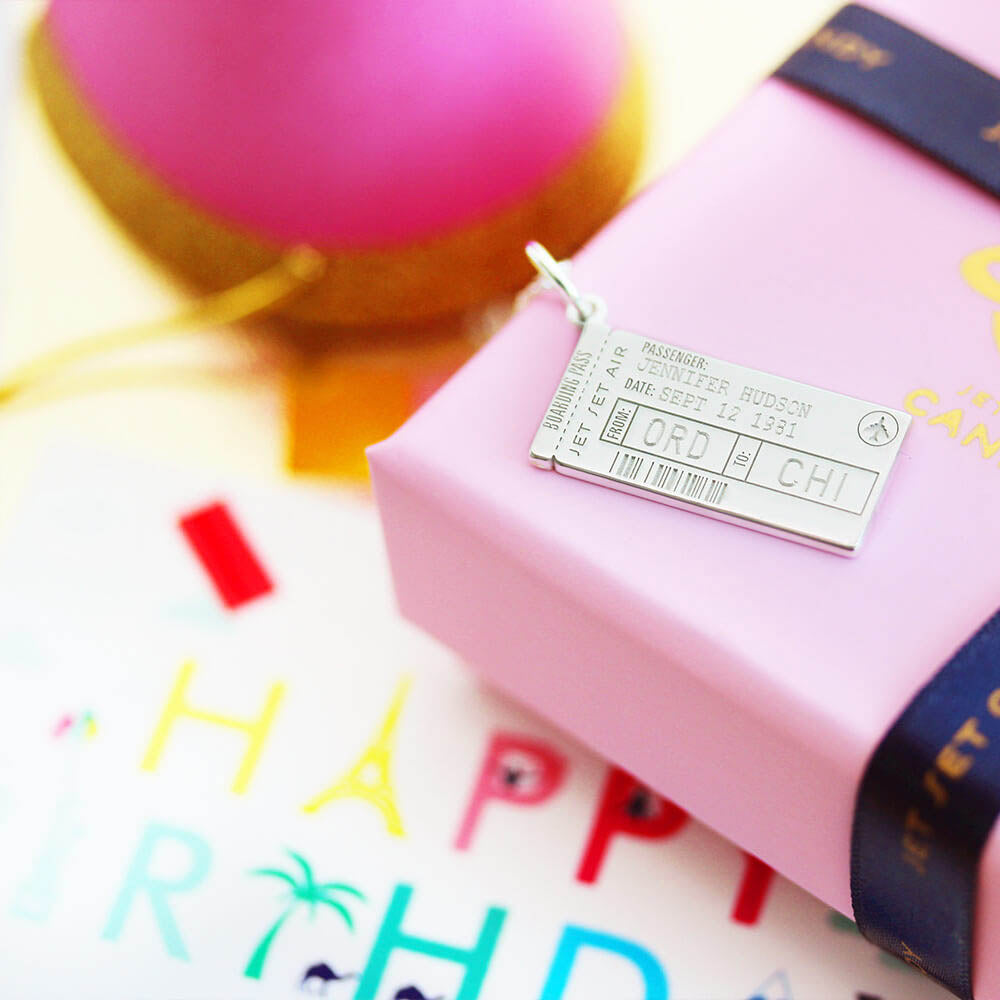 Sterling Silver boarding pass charm featuring engraved passenger name, ORD to CHI airport codes, barcode, and airplane icon motif.