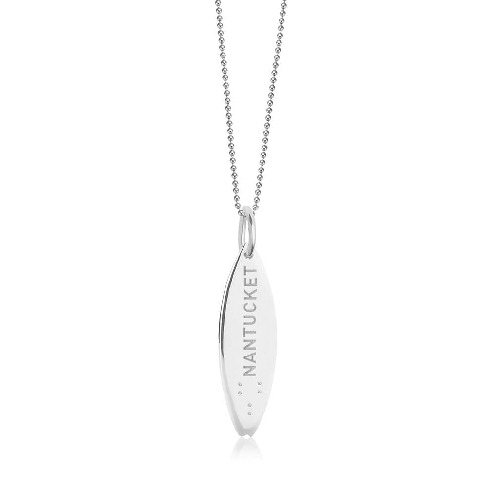 Sterling Silver surfboard charm featuring Nantucket engraving and Braille dots, hanging from a delicate silver bead chain necklace.