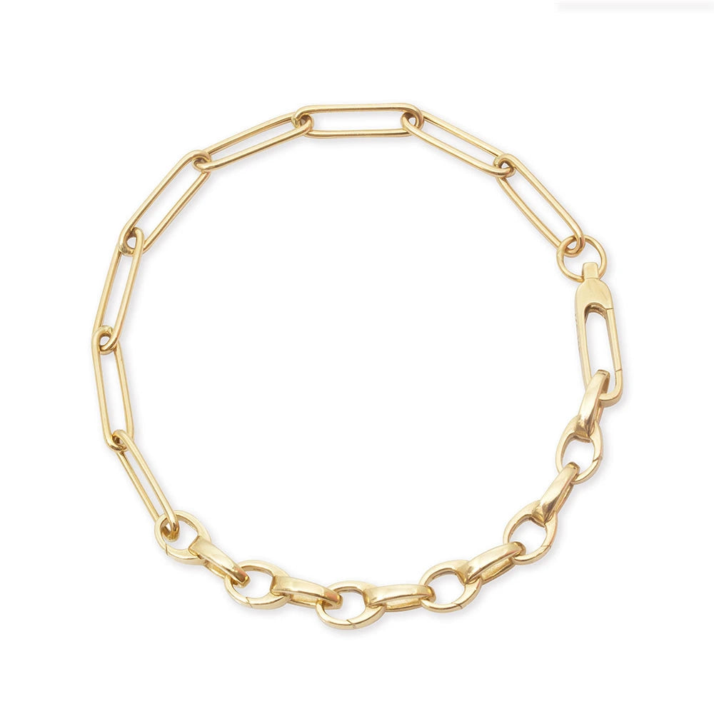Gold charm bracelet featuring a mixed chain design with elongated paperclip links, polished oval links, and a secure carabiner clasp.