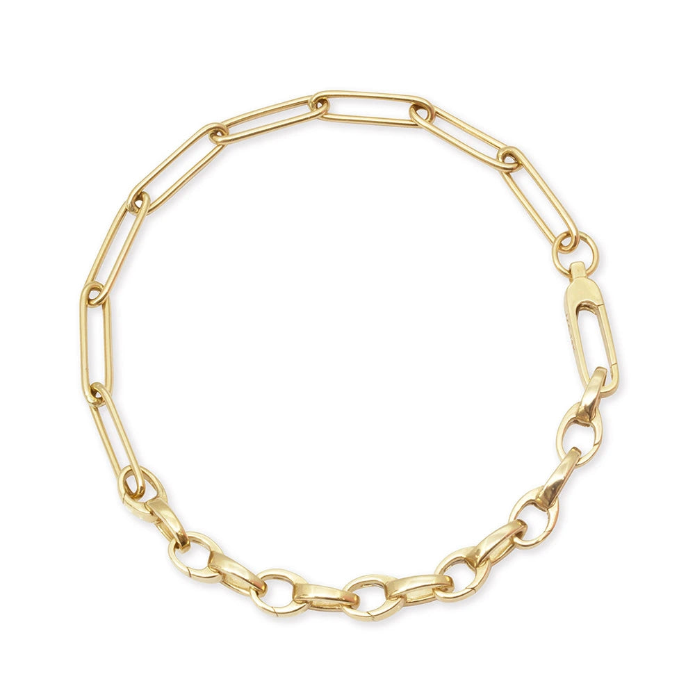 Gold charm bracelet featuring a mixed link design with elongated paperclip links, polished oval links, and a lobster clasp.