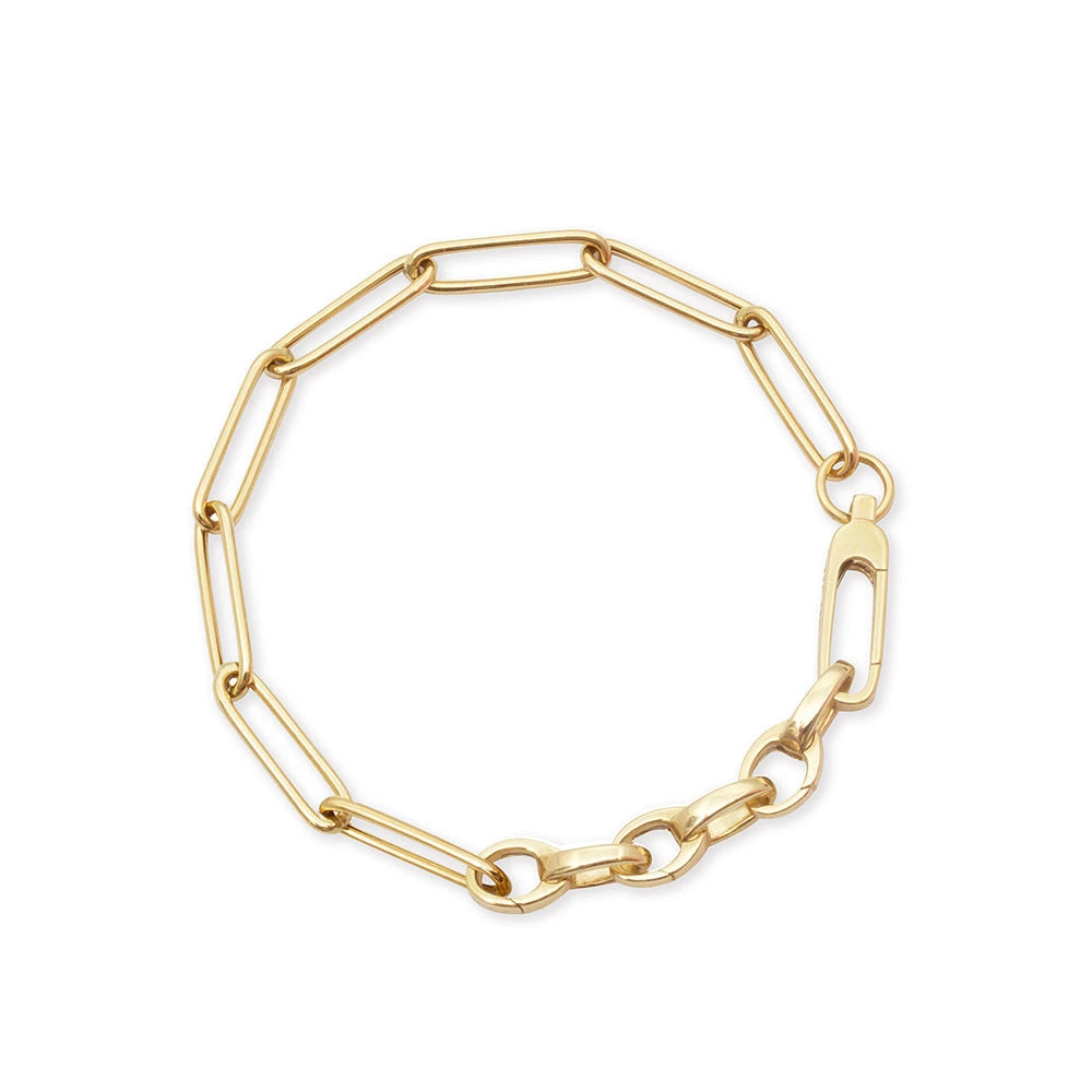 Gold paperclip chain bracelet featuring elongated rectangular links, a large lobster clasp closure, and smaller oval connector links.