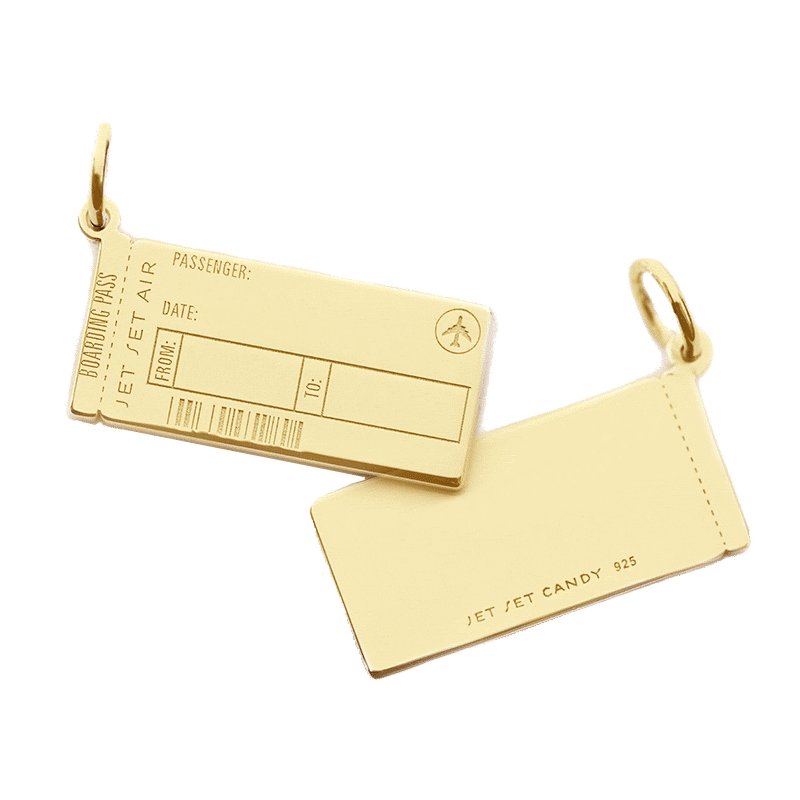Animated GIF of a solid 14k gold Boarding Pass Charm from Jet Set Candy shown on a white background. The customizable engraving is being animated. On the front, the engraving shows “Willy Wonka” as the passenger’s name and the letters  GLD and TKT in the to and from airport code fields and the back of the charm is engraved with “Dreamer of Dreams” The charm looks very similar to a real boarding pass and includes an airplane icon and fake engraved bar code.