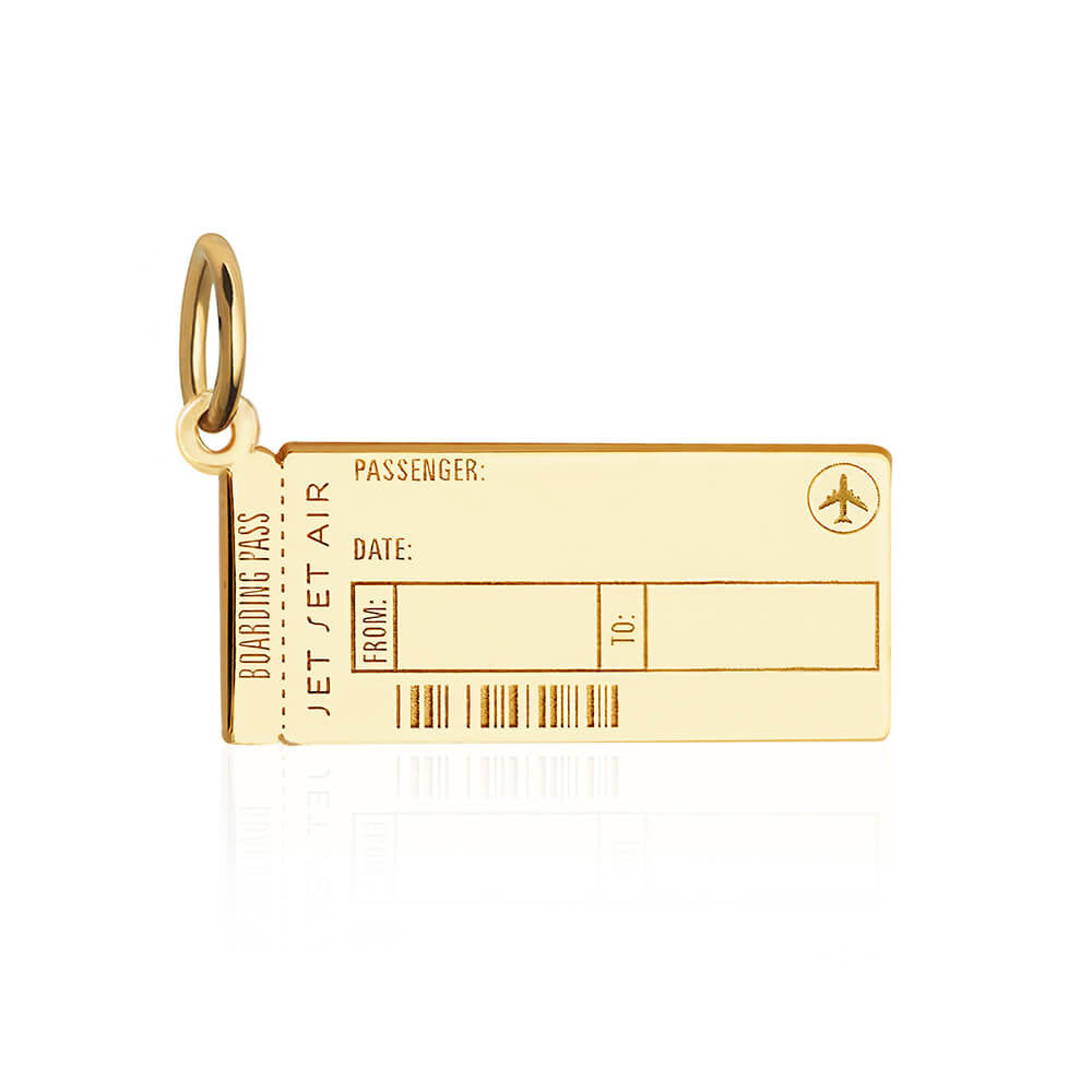 Photo of a gold vermeil Boarding Pass Charm from JET SET CANDY shown on a white background. The charm is completely customizable with fields for engraving for Name, Date, and airport codes as well as allowing for back engraving at an additional cost of $15. It looks very similar to a real boarding pass and includes an airplane icon and fake engraved bar code.