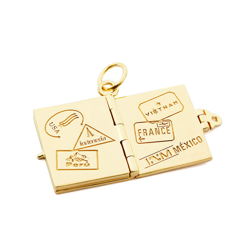 Bespoke Solid 14k Gold USA Passport Book Charm shown open to a spread of solid gold pages inside, sitting on a white background. This charm is fully customizable and you can choose up to 12 passport stamps to include on the solid gold pages inside. Shown in this photo are passport stamps for USA, Indonesia, Peru, Vietnam, France, and Mexico. This charm is a one-of-a-kind souvenir