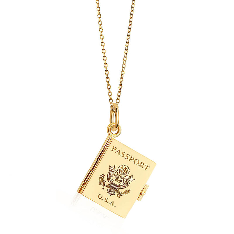 Bespoke Solid 14k Gold USA Passport Book Charm shown closed hanging on a gold chain on a white background. This charm is fully customizable and you can choose up to 12 passport stamps to include on the solid gold pages inside. This unique 14k solid gold travel charm features a front cover representing your country while the inside four pages will feature up to 12 countries of your choosing.