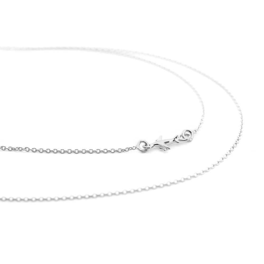 Sterling Silver “side plane” cable chain from Jet Set Candy featuring a tiny 7 mm long silver airplane charm in the middle of the side of the chain. The chain is shown here in a snaking position atop a white background.