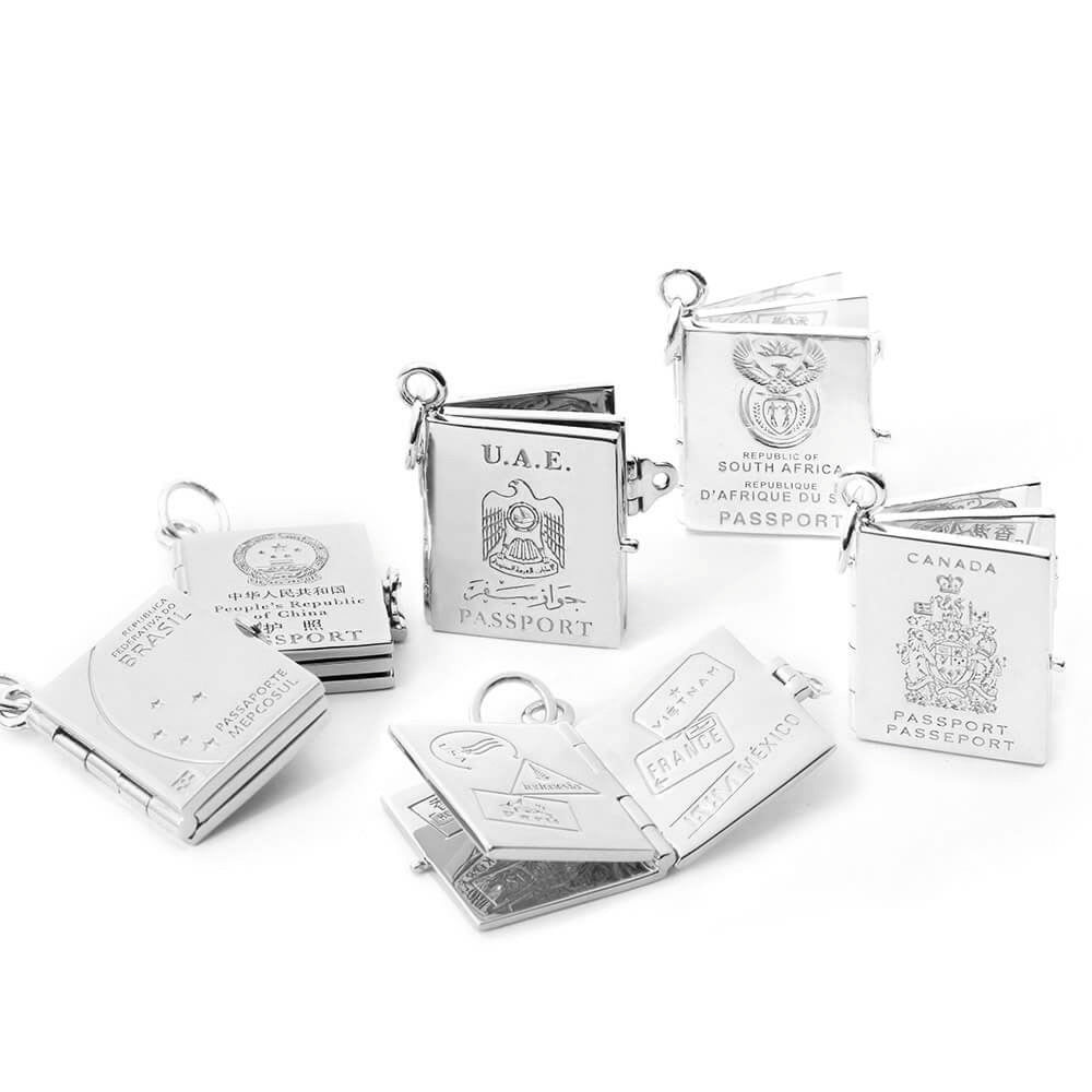 Silver passport book charms by Jet Set Candy, shown open to reveal intricate interior engravings on a white background.