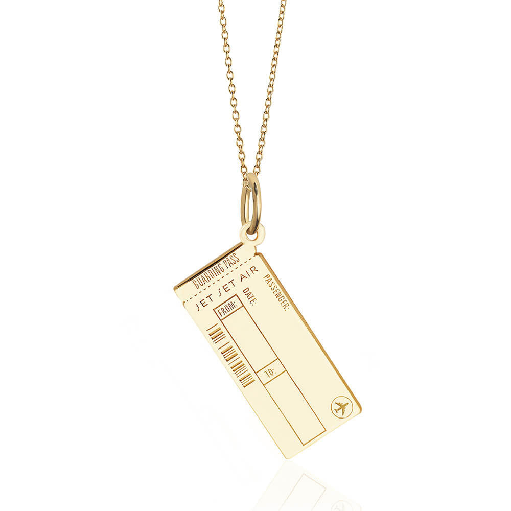 Photo of a solid gold Boarding Pass Charm hanging on a thin cable chain from JET SET CANDY shown on a white background. The charm is completely customizable with fields for engraving for Name, Date, and airport codes as well as allowing for back engraving at an additional cost of $15. It looks very similar to a real boarding pass and includes an airplane icon and fake engraved bar code.
